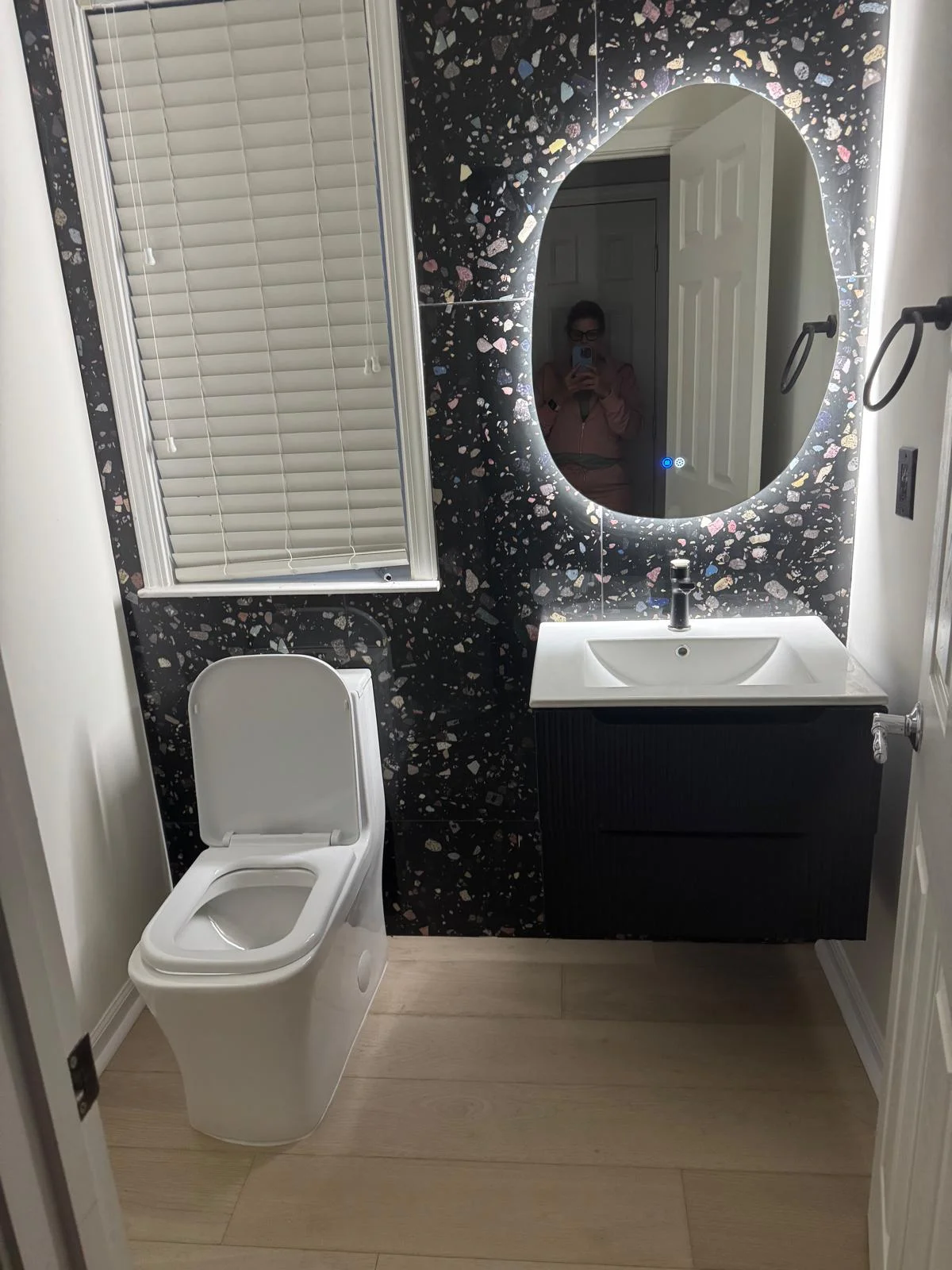 Powder room after renovation — modern fixtures and statement tile