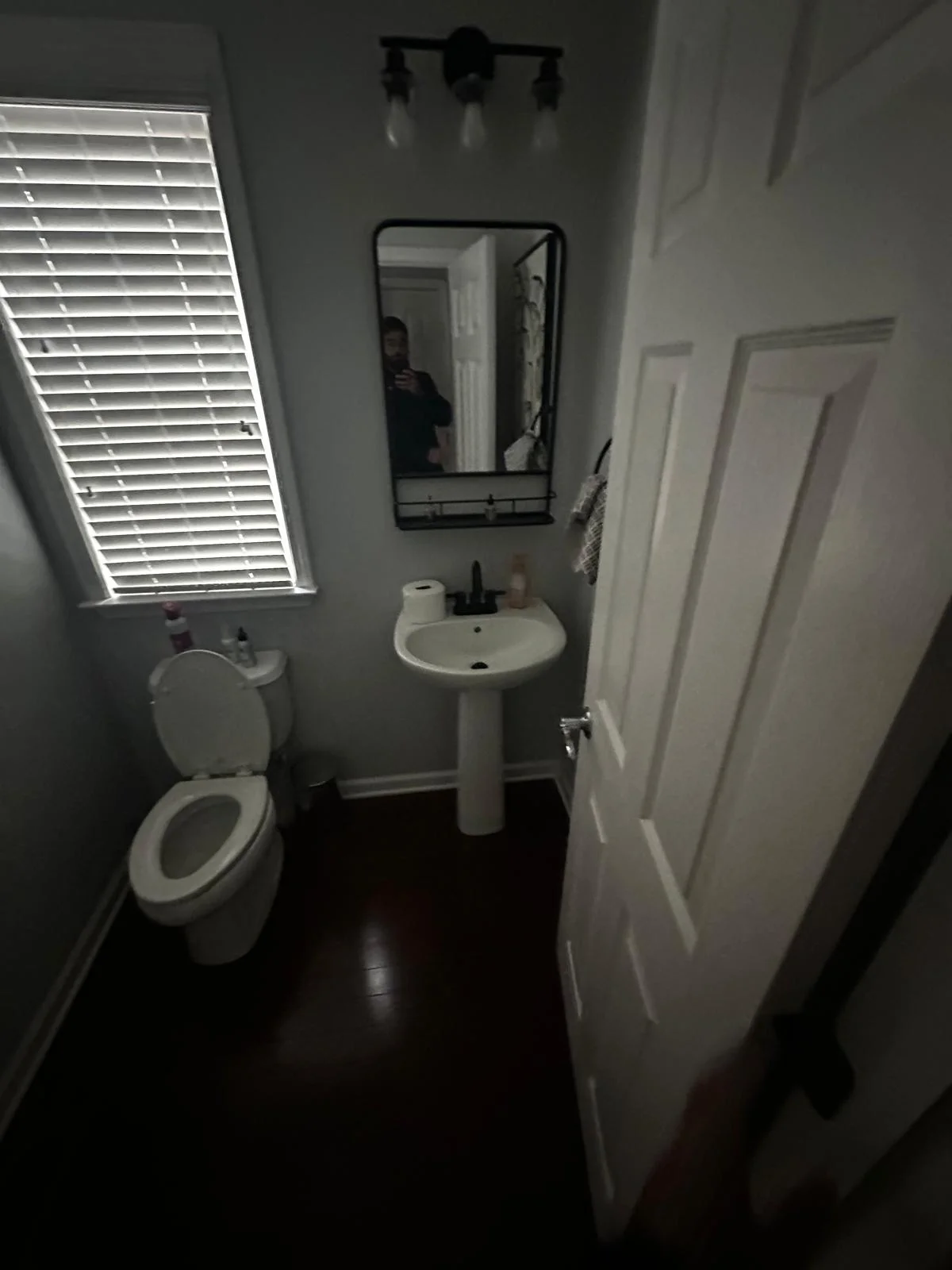 Powder room before renovation — dated fixtures and basic finishes